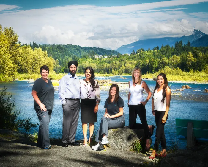 Group photo of the dental office team posing outdoors with a scenic mountain backdrop